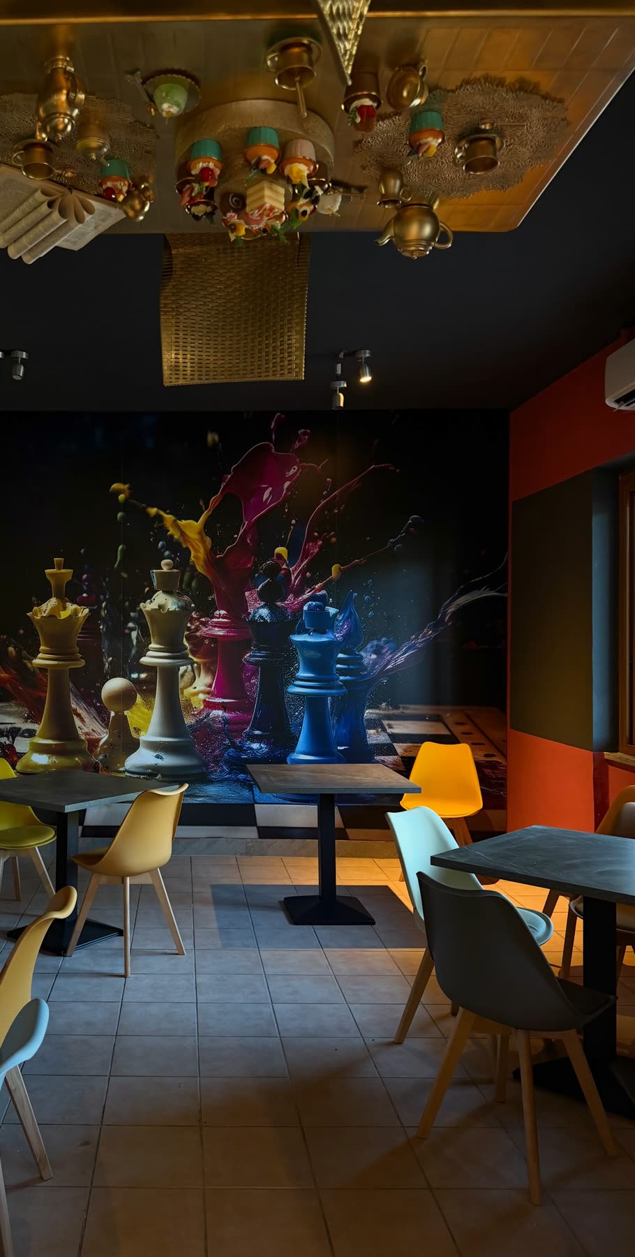 I tavoli e le sedie colorate della sala del White Rabbit, con il tavolo da tè capovolto sul soffitto